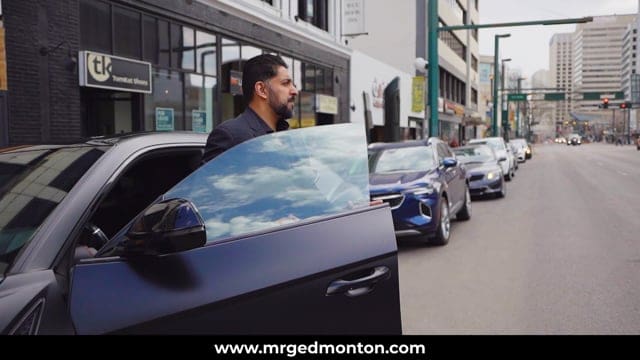 Modern urban street scene with a man standing beside a luxury car, showcasing city life and automotive culture.