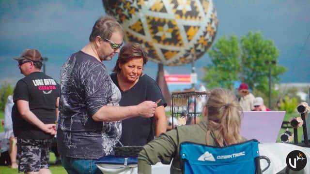 Q Filmz Media event featuring people engaging with local community activities outdoors during daytime with a colorful hot air balloon in the background.
