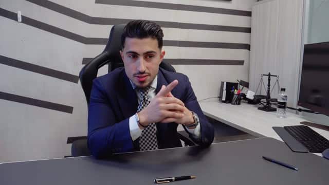 Professional young man in a suit sitting at a modern office desk, ready for a business meeting or presentation.
