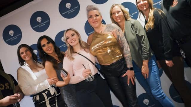 Women group networking at Q Filmz Media event, diverse professionals smiling, corporate event, media company branding, professional networking, team celebration at Q Filmz.