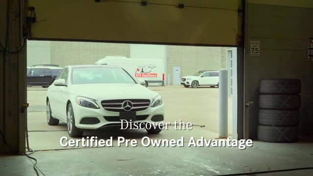 Mercedes-Benz white luxury sedan exiting a garage, promoting certified pre-owned vehicles at Q Filmz Media.