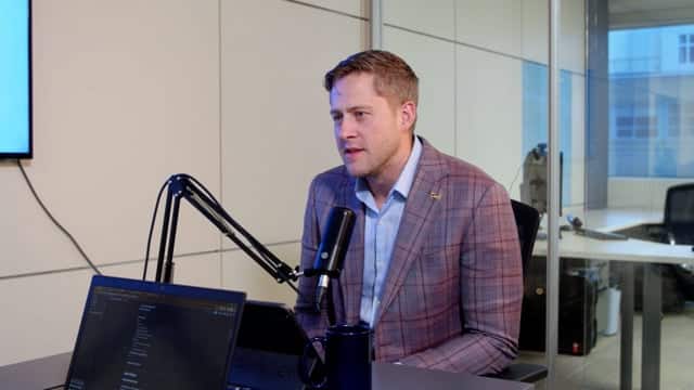Professional male podcast host speaking into microphone during recording session in modern studio; media, broadcasting, and content creation.